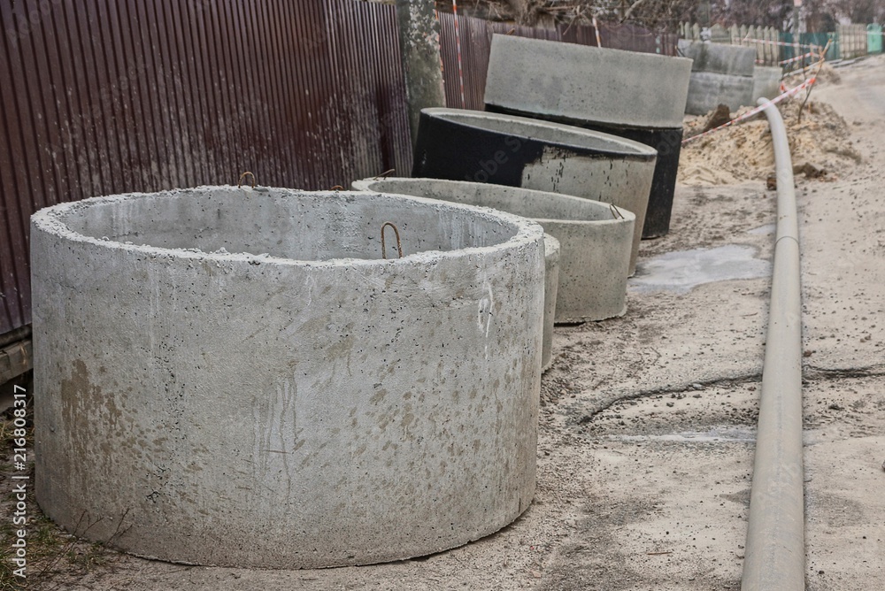 concrete circles and rings near a fence on street repair