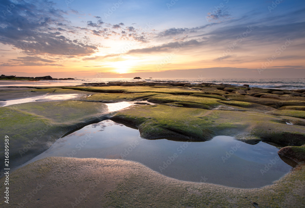 sunset seascape with beautiful rocks formation covered by green moss. soft focus due to long expose. s