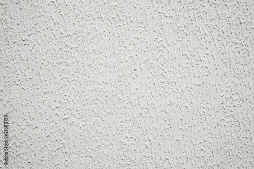 abstract background: Decorative plaster with a rough surface, painted with outdoor paint in white color