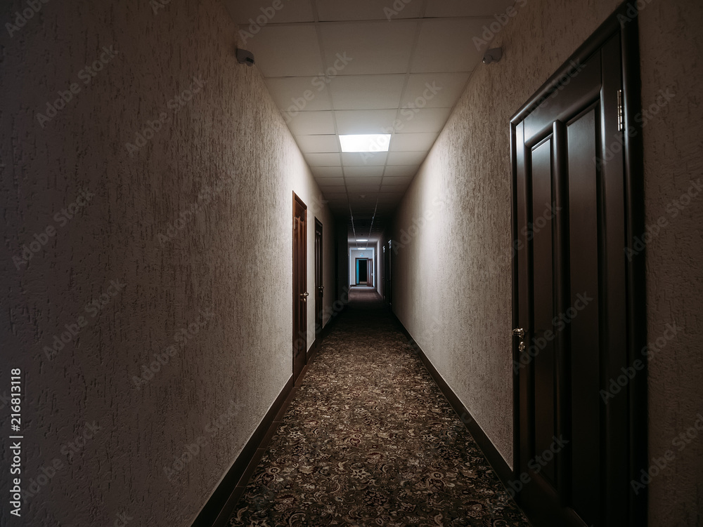 Empty dark corridor in apartment building, doors, lighting lamps Empty dark corridor in apartment building, doors, lighting lamps