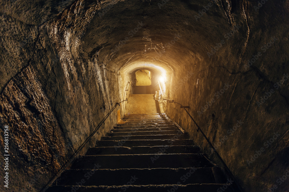 Dark corridor of old abandoned underground Soviet military bunker. Staircase goes down 