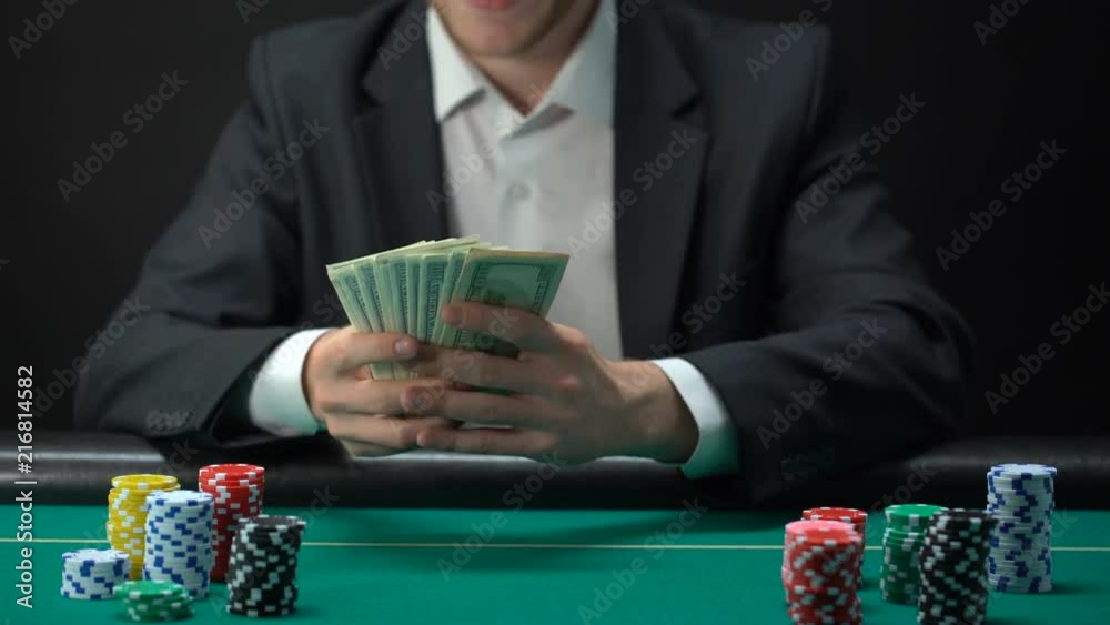 Lucky casino winner holding dollar banknotes, chips on table around, game award Lucky casino winner holding dollar banknotes, chips on table around, game award