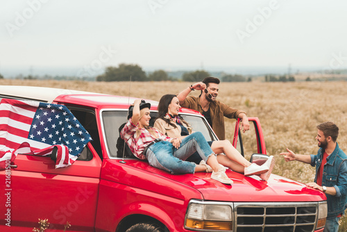 Εκτύπωση καμβά group of young american car travellers relaxing in flower field