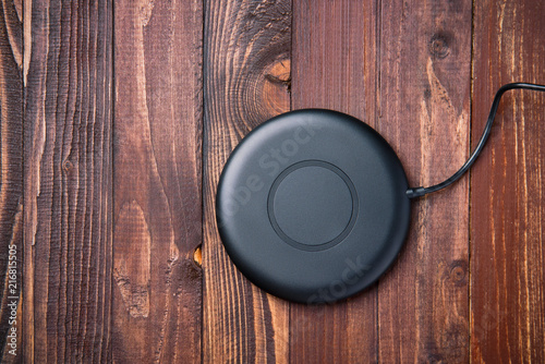 Wireless charger for mobile phone on a wooden background