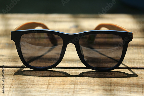 Sunglasses on the wooden table in the morning photo