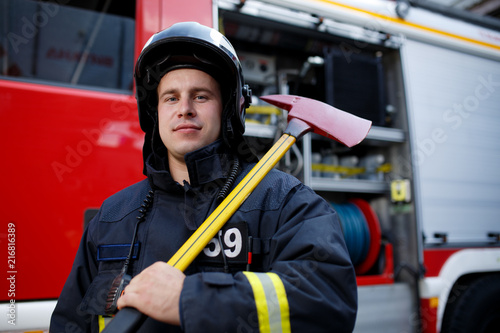 Photo of fireman with hammer against fire machine