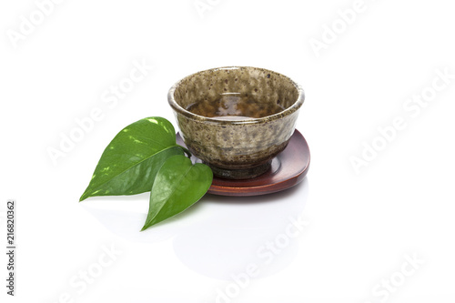 asian tea cup with a leaf isolated white.