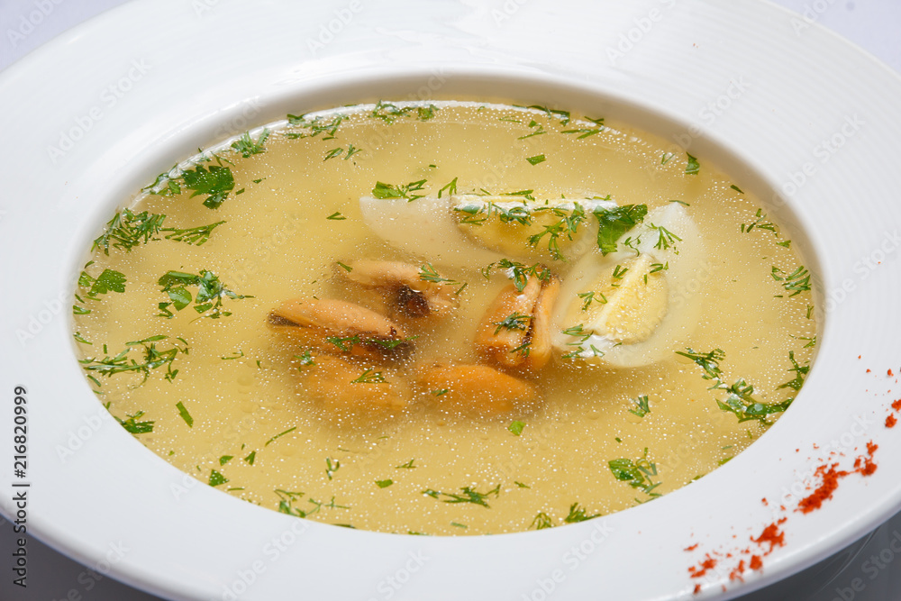 Soup with dumplings, egg and greenery. White background. Yellow. Soup with dumplings, egg and greenery. White background. Yellow.