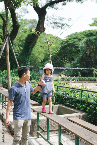  Happy family having fun with animals safari park on warm summer day.