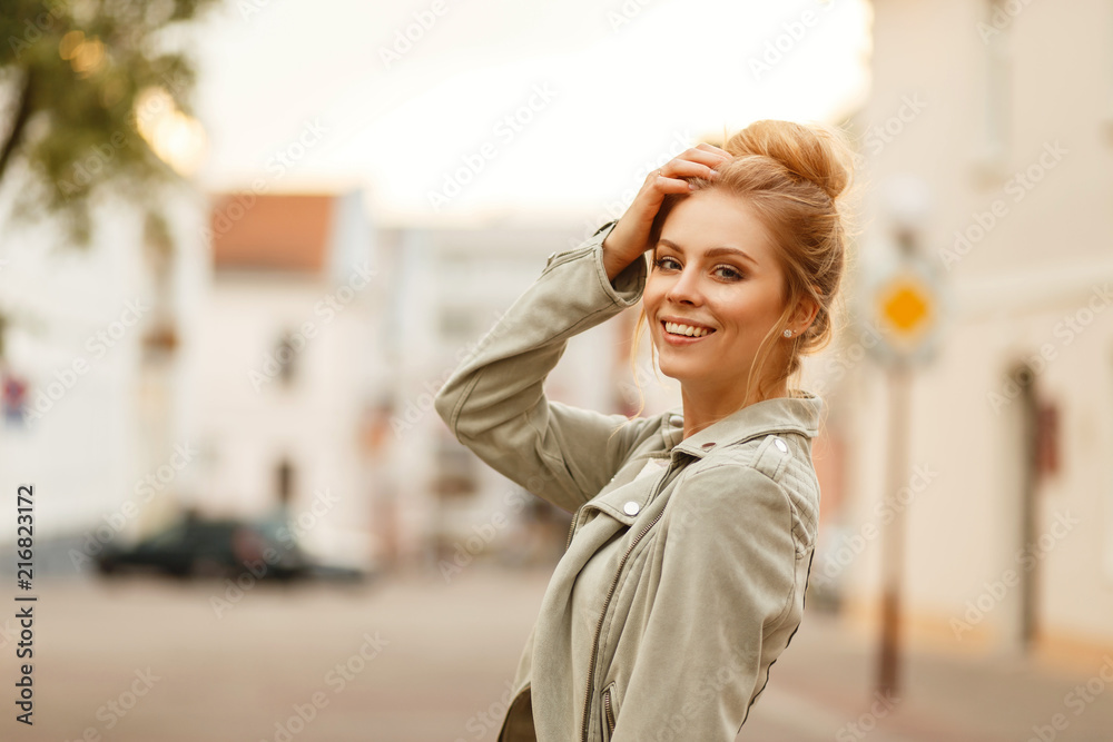 Fototapeta premium Stylowa piękna młoda kobieta uśmiechając się w modnej jesiennej kurtce w mieście
