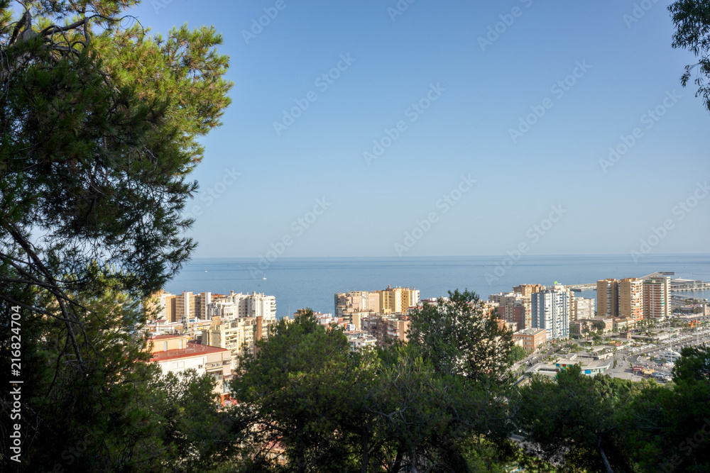 Spain, Malaga, a view of a city with tall buildings in the background