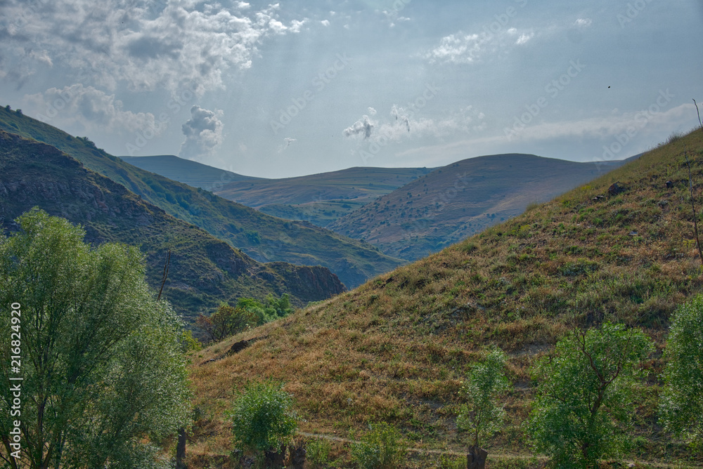 Obraz premium Mountain landscape with clouds and grass