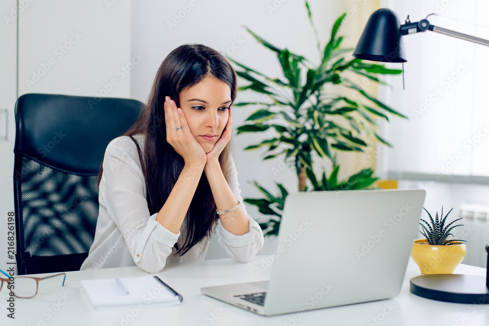 Tensed Businesswoman Using Laptop At Desk Tensed Businesswoman Using Laptop At Desk