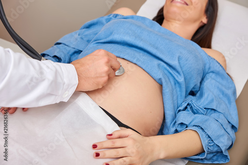 Closeup view of a pregnant womans belly during checkup.