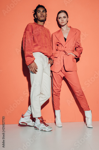 Casual couple in red leaning against a red wall