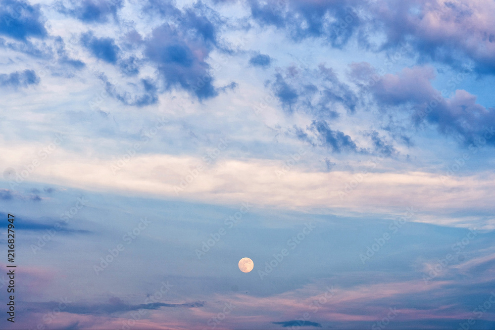 Scenic view of late evening sky with full moon and purple clouds.