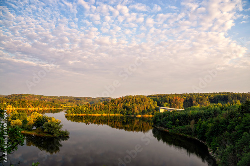 Colourful sunset over a lake. Summer scene of wide river landscape with setting sun. © 1tomm