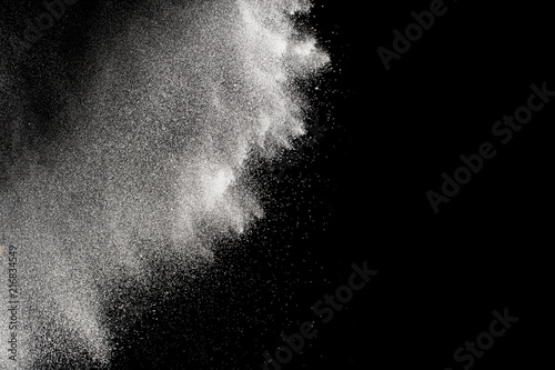 Freeze motion of white particles on black background. Abstract white dust explosion. 