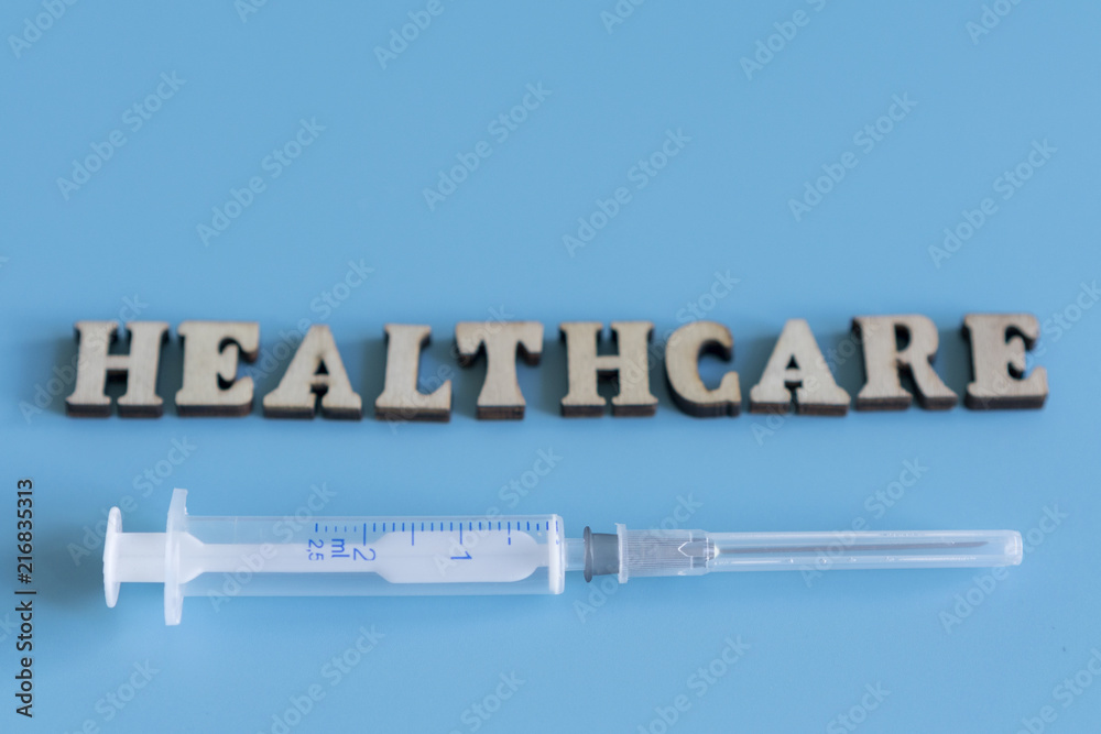 inscription healthcare on a blue background. Syringe on blue background