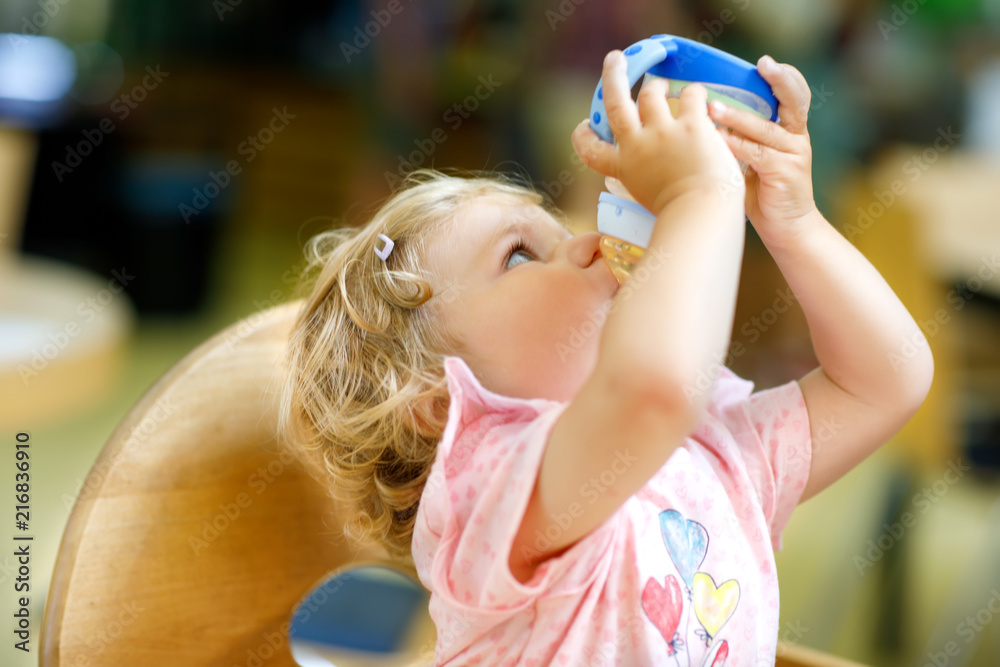 Toddler girl drinking water from the baby bottle Stock Photo