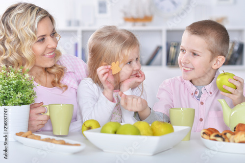 Happy mother and children having breakfast together