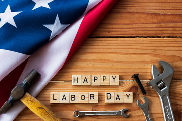 USA Labor day concept, First Monday in September. Different kinds on wrenches, handy tools, America flag and wooden blocks on wooden table.