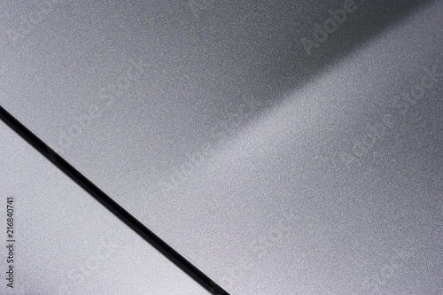 Surface of gray sport sedan car, detail of metal hood and bumper of vehicle bodywork