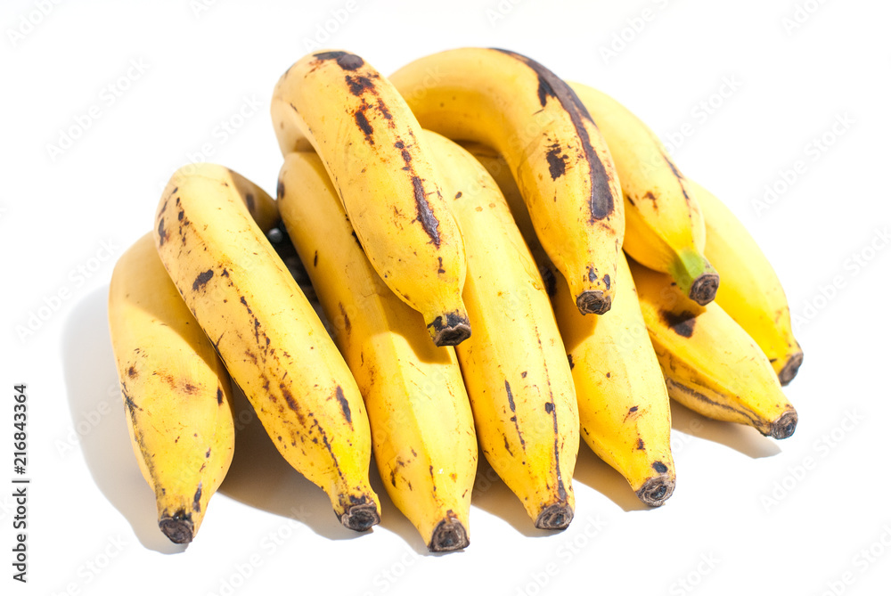 Golden yellow ripped banana with some stains isolated on white background and strong light