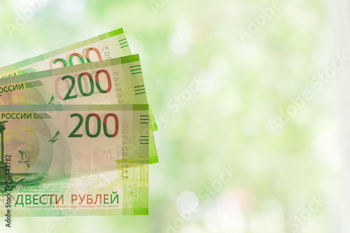 new russian banknotes against green bokeh background. two hundred roubles. Cash paper money.