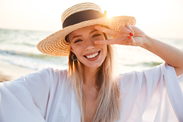 Delighted young girl in summer hat and swimwear