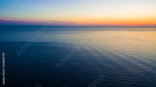 Drone view of a wide sea surface and the horizon at sunset  