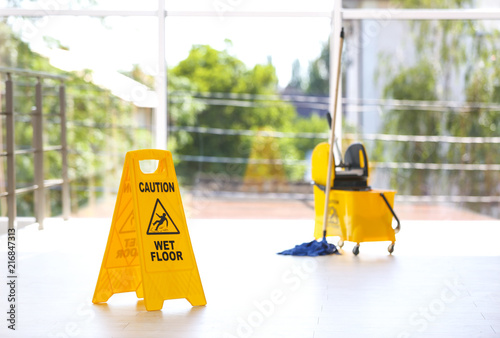 Wallpaper Mural Safety sign with phrase Caution wet floor and mop bucket, indoors. Cleaning service Torontodigital.ca