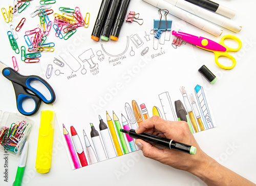 woman hand sketching a picture of stationery with a marker. White background with different stationery