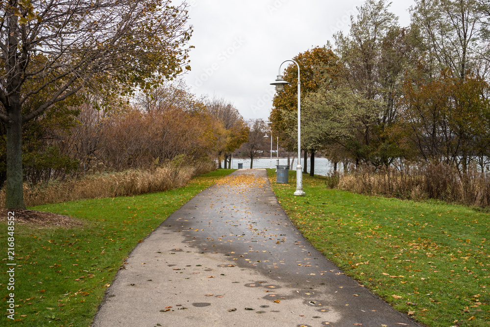 Paved Path Lined with Bare Trees in a Lakeside Park in Autumn. Hamilton, On, Canada.