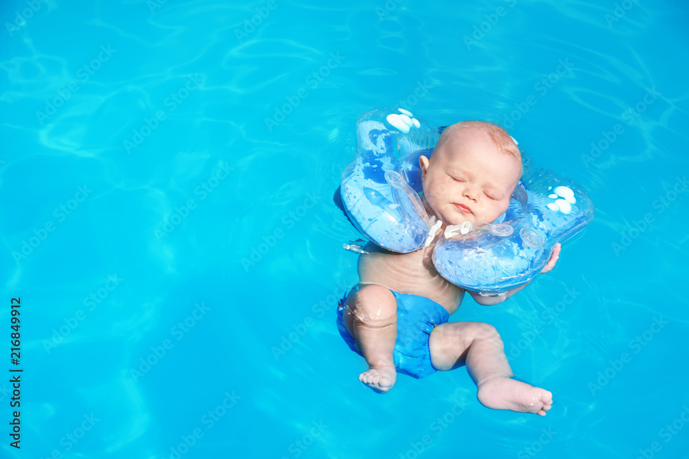 Cute little baby with inflatable neck ring in swimming pool on sunny day,  outdoors Stock Photo | Adobe Stock