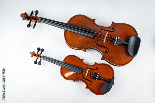 Two violins put on white background,show the different size of violin.