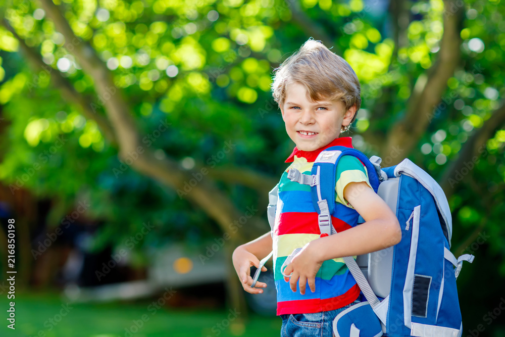 little kid boy with school satchel on first day to school