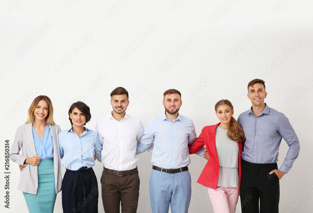 Group of young people hugging each other on light background. Teamwork concept Group of young people hugging each other on light background. Teamwork concept