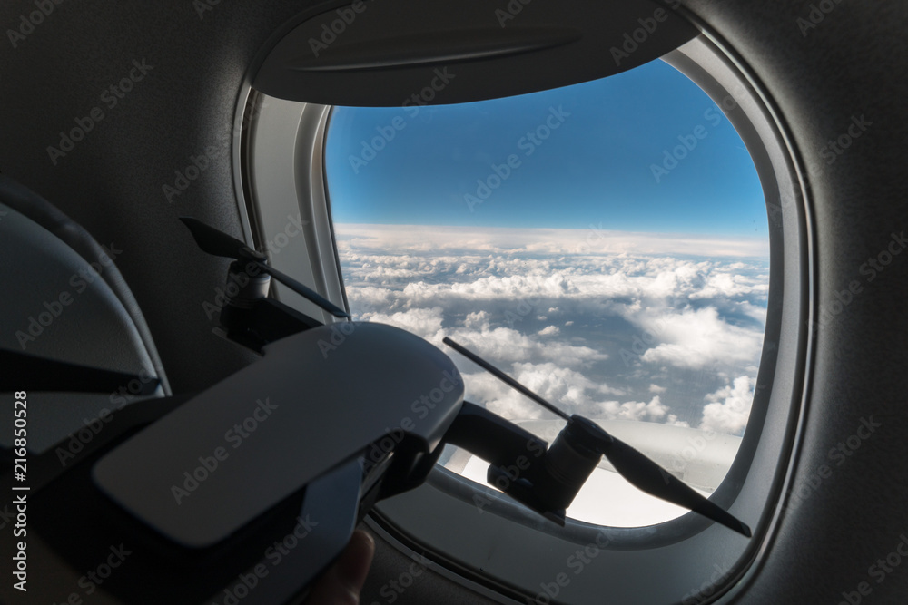 a small drone looks out the window of an airplane at an altitude of 15,000 m, 10000 feet