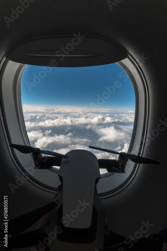 a small drone looks out the window of an airplane at an altitude of 15,000 m, 10000 feet, vertical photo