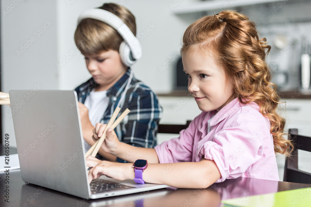 little brother and sister doing homework and using laptop little brother and sister doing homework and using laptop