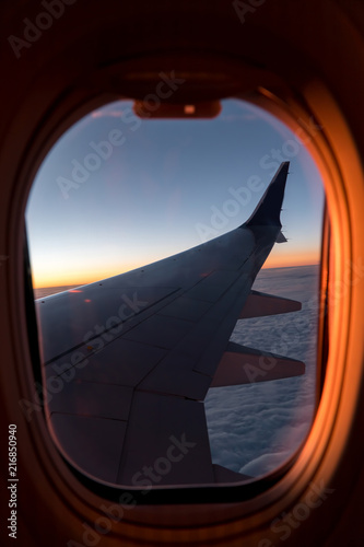 view from the airplane window to the wing  evening  sunset  clouds  concept of night voyages and travels  vertical photo