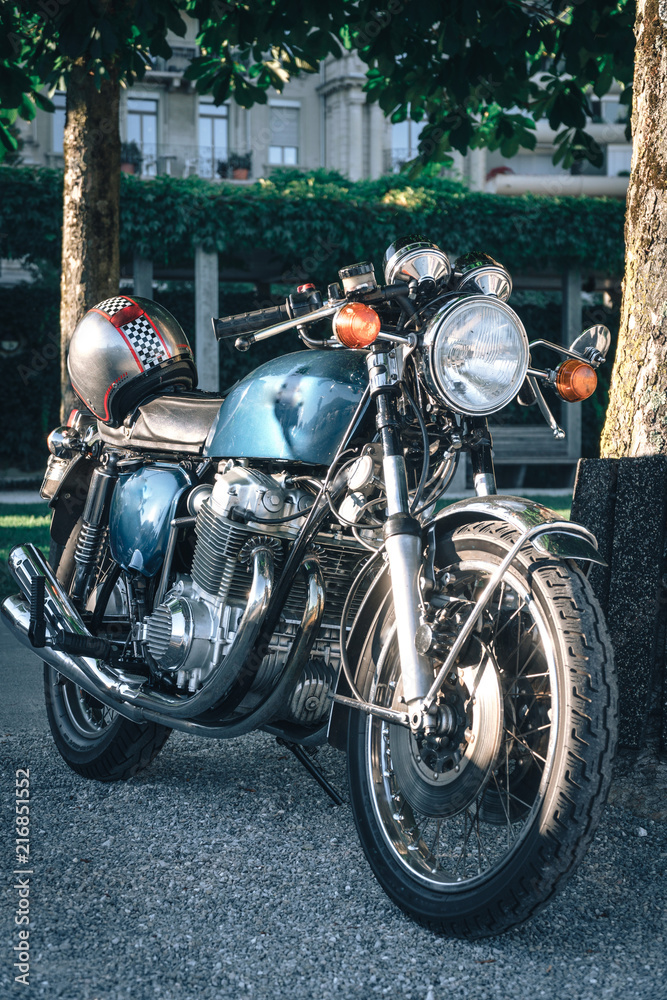 close up of detail of classic style cafe racer motorcycle at sunset time. Bike custom made in vintage. Brutal fun urban lifestyle, vertical photo close up of detail of classic style cafe racer motorcycle at sunset time. Bike custom made in vintage. Brutal fun urban lifestyle, vertical photo