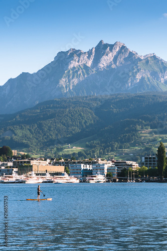 man are doing yoga on a stand up paddle board SUP on a beautiful Lake Lucerne, Pilatus mountain the summer season, boats and ships, travel and vacation to Europe concept, Luzern, Switzerland