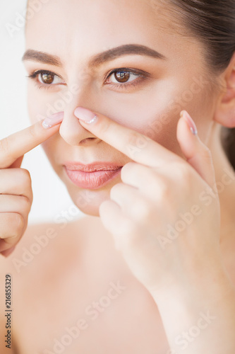 Skin Care. Beautiful Woman Squeezing Pimple at Bathroom Mirror