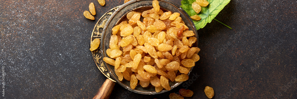 Heap of yellow raisins on brown concrete background. Top view of dried grapes. Heap of yellow raisins on brown concrete background. Top view of dried grapes.