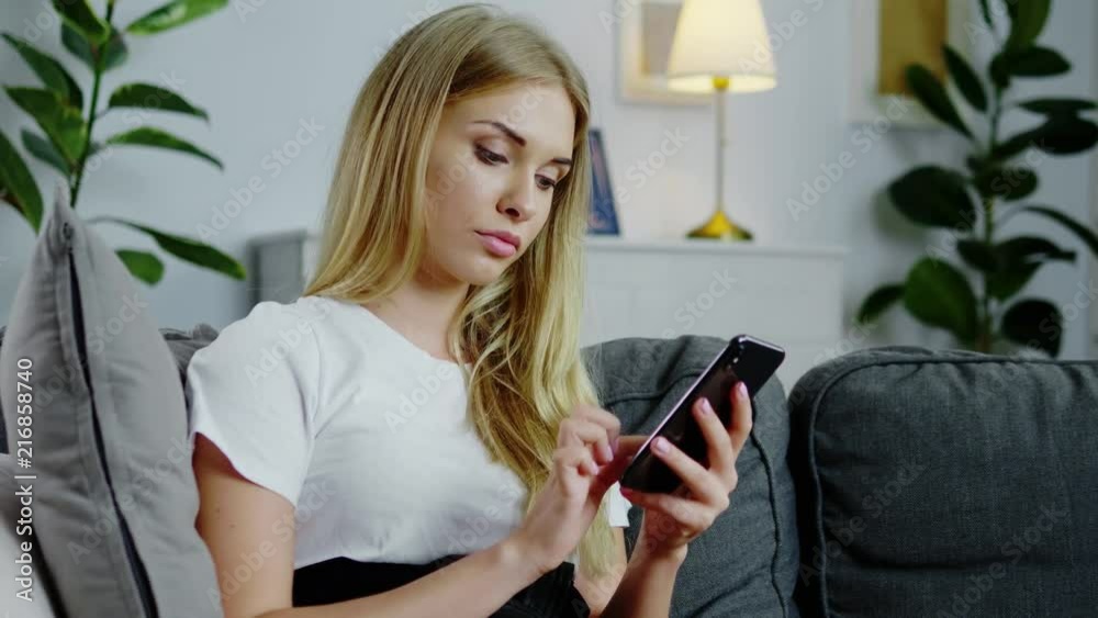 Beautiful woman using her smartphone in the living room Beautiful woman using her smartphone in the living room