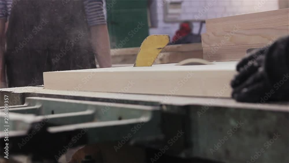 sawing a wooden board with a circular saw. sawing a wooden board with a circular saw.