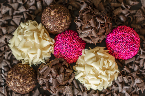 colorful brigadeiros brazilian sweets arranged over chocolate curls photo