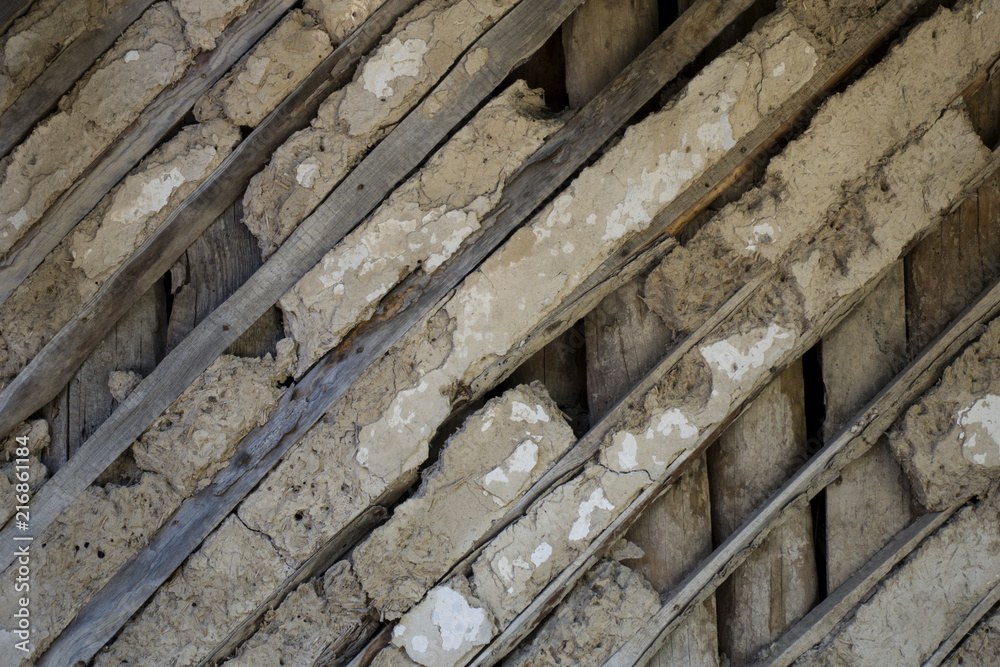 Old wall of wattle and daub house with wooden diagonal stripes. Vintage texture background. Rustic view. Old wall of wattle and daub house with wooden diagonal stripes. Vintage texture background. Rustic view.